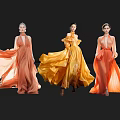 Women Showcasing Flowing Orange Yellow Long Dresses Against Black Background
