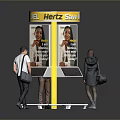 Yellow Easy Fuel Here Display Kiosk with People Interacting Around and Advertisement Poster On It