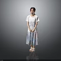Woman in white T-shirt and colorful long skirt with sandals against gray background