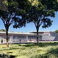Modern Visitor Center Over Water With Pillars Surrounded By Green Trees And Blue Sky
