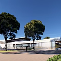 Modern Visitor Center Over Water With Pillars Surrounded By Green Trees And Blue Sky