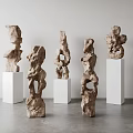 Hand Carved Irregular Wooden Sculptures on White Cube Pedestals with Light Walls and Gray Floor
