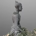Stone Carved Buddha Sculpture In Sitting Posture With Moss And Fallen Leaves