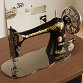 Vintage Black Gold Sewing Machine With Decorative Design And Metal Wheel On Wooden Table