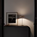 Minimalist Modern Table Lamp Illuminating Wooden Side Table With Framed Artwork And Small Coffee Mug