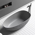 Round Gray Stone Bathtub in Modern Bathroom Interior with White Wooden Floor and Wall Niche