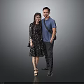 Man In Blue Shirt And Woman In Floral Dress Standing In Gray Background