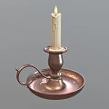 Lit White Candle On Brass Candlestick With Handle And Round Base
