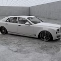 White Luxury Sedan with Black Wheels in Modern Indoor Space on Sleek Reflective Floor
