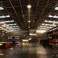 Spacious Warehouse Interior With High Metal Roof Skylights Multi Level Shelves And Smooth Black Floor