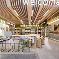 Modern Supermarket Interior With Welcome Sign Shelves Products Checkout Counter And Stools