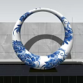 Garden Landscape With Blue and White Circular Sculpture Floral Patterns Stone Wall and Water Surface