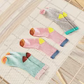 Colorful Patterned Socks Laid Out On Wooden Drying Rack With Mesh Cloth