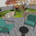 Garden Landscape Outdoor Seating With Green Armchairs Round Table Stone Pavement Rocks And Autumn Tree