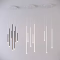 Modern Black and White Slender Tube Chandeliers Hanging from White Ceiling with Illuminated Lights