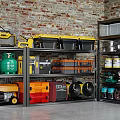 Organized Metal Storage Shelves With Tools Storage Boxes And Gas Cylinders By Brick Wall