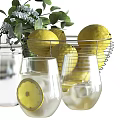 Elegant Decorative Ornament Set With Lemons Glass Bottle Cups Whisk And Green Foliage