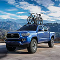 Blue Toyota Tacoma Truck With Bicycles On Roof Rack And Mountain Landscape