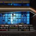 Modern Restaurant Bar Counter With Blue Glass Wall Wine Bottles Warm Lighting And Displayed Fruits