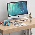 Computer Monitor Desktop Setup with Keyboard Mouse Blue Headphones Magazines Coffee Cup on Wooden Desk