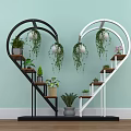 Heart Shaped Black And White Shelving Unit With Hanging Plants And Potted Greenery