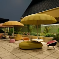 Stylish Outdoor Sofa Setup With Yellow Umbrellas Green Plants And Paved Patio