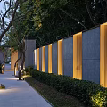 Illuminated Landscape Wall With Concrete And Wooden Slats Along Evening Pathway Trees And Bushes