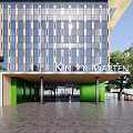 Modern Kindergarten Building Featuring Glass Windows Green Entrance Front Sign And Trees Around