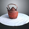 Red Carved Teapot Sculpture With Handle And Spout On White Circular Cloth