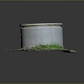 Gray Cylindrical Concrete Structure With Round Lid Surrounded By Green Grass And Dirt