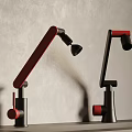 Red And Black Faucets With Curved Long Handles On Countertop Against Gray Wall Background