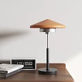 Modern Table Lamp with Orange Shade Black Stand on Wooden Desk with Clock and Books