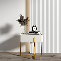 White Bedside Table With Gold Legs Vase Feather Plant And Black Alarm Clock
