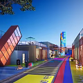 Vibrant Modern Commercial Street With Colorful Ground Container Buildings Glass Facades And Outdoor Seating