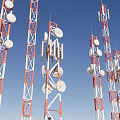 Red and White Communication Towers With White Antennas Satellite Dishes Against Blue Sky