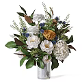 Decorative Floral Arrangement In Vase With White Roses Hydrangeas Blue Accent Flowers And Green Leaves