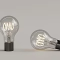 Two Vintage Spiral Filament Light Bulbs Standing And Tilted With Transparent Glass