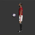 Man in Red Manchester United Jersey Standing with Soccer Ball and Arms Outstretched on Gray Background