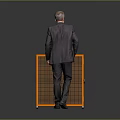 Elderly man in suit standing beside orange grid cabinet with black countertop areas