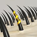 Black Spikes With Yellow Striped Band On Textured Beige Surface