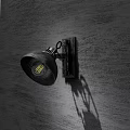 Vintage Industrial Wall Lamp With Metal Frame And Black Shade Casting Shadow On Wooden Wall