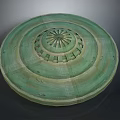 Green Circular Decorative Disc With Concentric Rings And Central Radial Pattern
