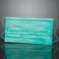 Green Three Layer Face Mask With Ear Loops Featuring Reflection On Black Background