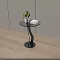 Round Glass Top Coffee Table With Black Curved Base Green Plant And Books On Light Wooden Floor