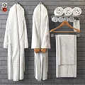 Soft White Textured Bath Towels And Robe Hanging On Rack Against Bricks Wall Bathroom
