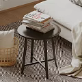 Modern Round Side Table With Stacked Books And Wicker Basket Near Bed On Patterned Rug
