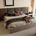 Modern Double Bed With Upholstered Headboard Gray Brown Pillows Layered Blanket And Nightstand Lamp