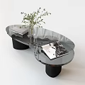 Modern Glass Coffee Table With Black Cylindrical Legs Magazine Books And Vase With Green Plant