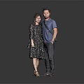 Man In Blue Shirt And Woman In Floral Dress Standing In Gray Background
