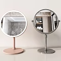 Round Tabletop Vanity Mirrors With Pink And Silver Bases And Illuminated Circular Design